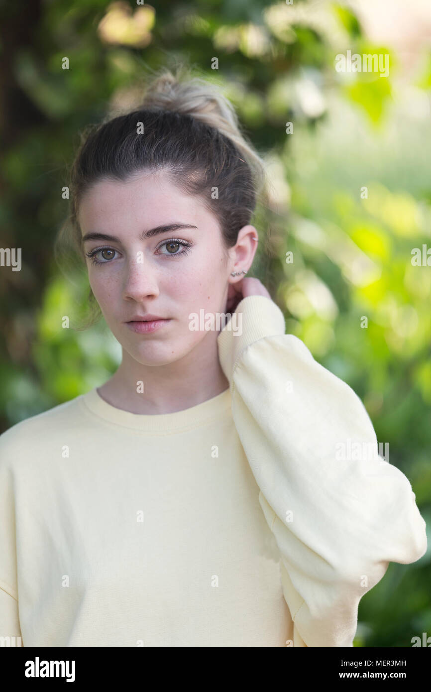 Portrait d'une jeune adolescente dans un jardin. Tir vertical avec lumière naturelle. Banque D'Images
