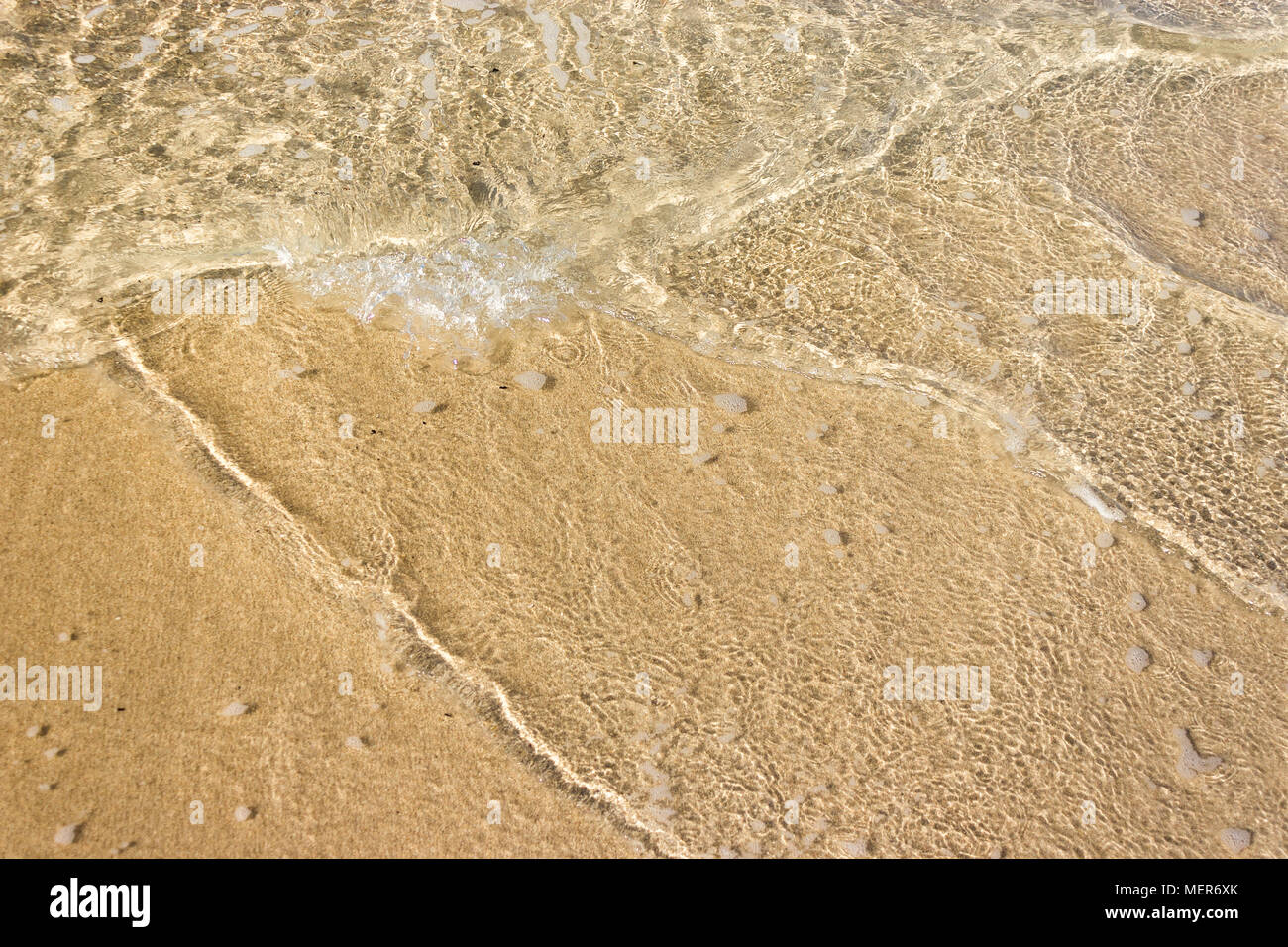 Vagues douces avec de la mousse de l'océan sur la plage de sable contexte Banque D'Images