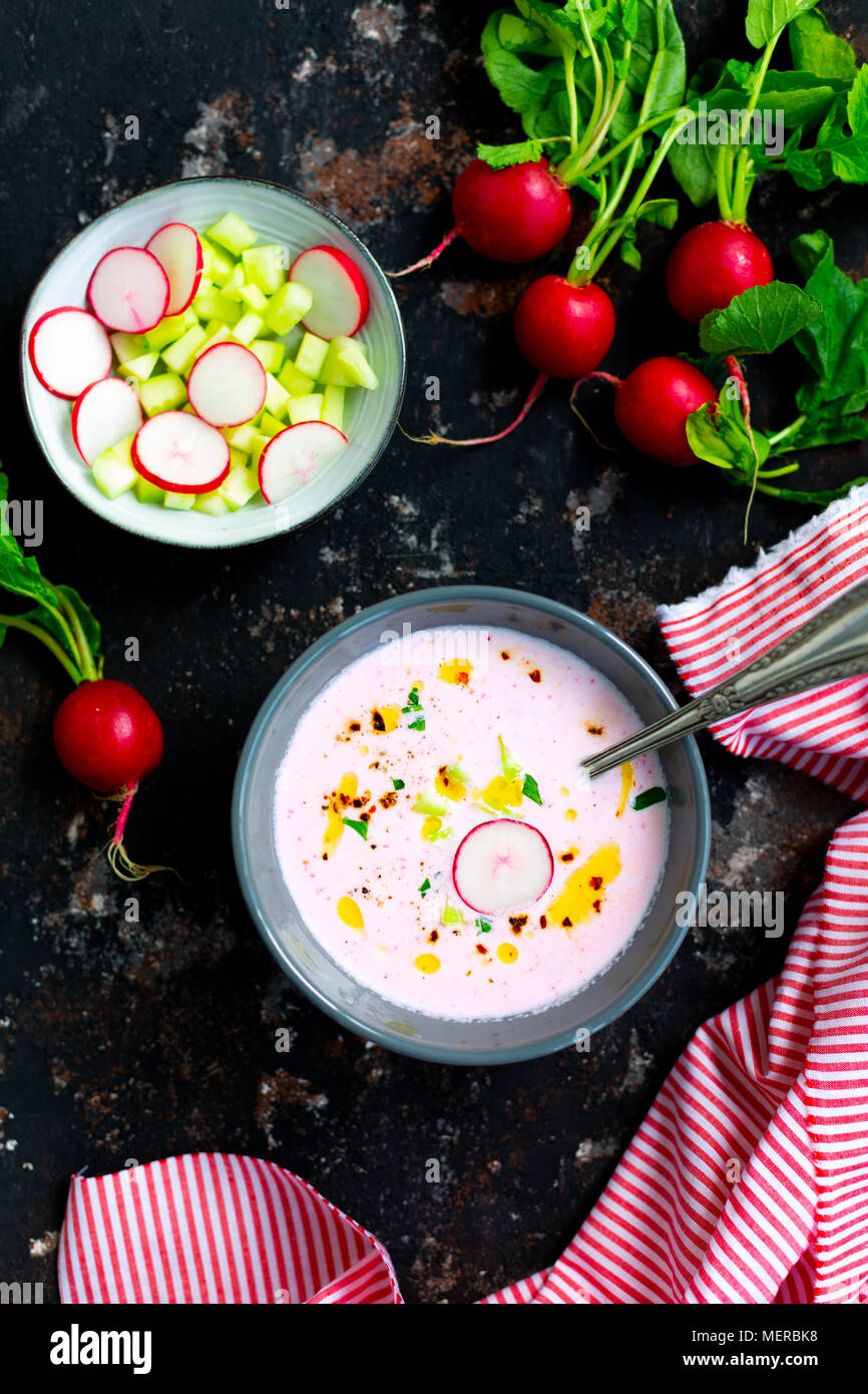Soupe de radis froide rose avec le concombre et yaourt garnie de piment sec, le poivre, le persil, l'huile d'olive et servi dans des bols crudités Banque D'Images