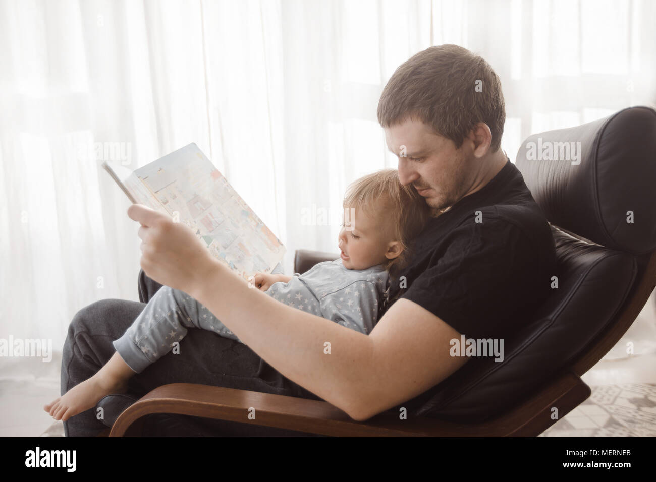 Père et petit bébé garçon avec livre à la maison Banque D'Images