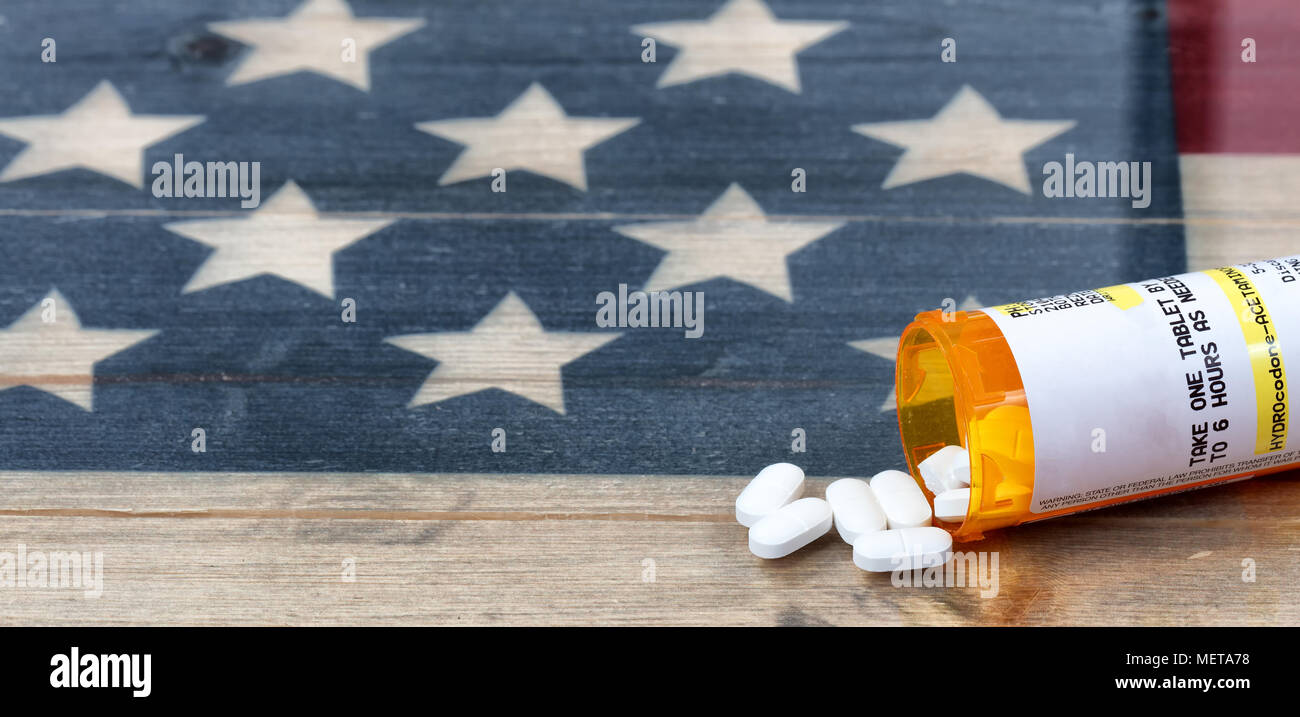 Bouteille de prescription Hydrocodone ou opioïdes générique comprimés contre la douleur avec drapeau USA rustique en arrière-plan pour la toxicomanie concept en Amérique Banque D'Images