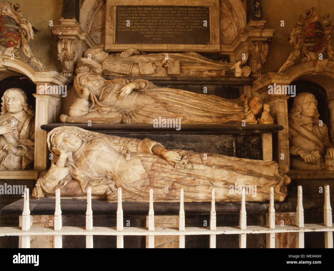 La tombe de Sir Roger Smith Chevalier à Edmondthorpe église, Melton Mowbray, Leicestershire, Angleterre l'albâtre des effigies de Sir Roger et ses deux femmes, Jane née Heron (d.1599) et Anne nee Goodman (d.1652) en dessous de lui. Son fils Edouard (d.1632) âgés de 34 ans et son petit-fils Roger (d.1646) sont indiquées de 19 ans et d'autre. L'effigie de Lady Ann Smith, a une tache rouge sur le poignet. Elle était considérée comme une sorcière qui pourrait se transformer elle-même en chat. Banque D'Images