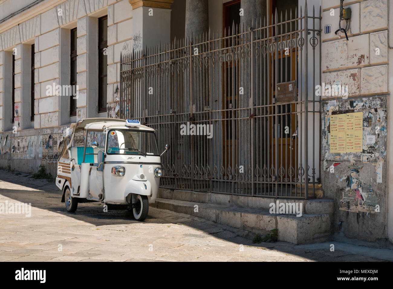 Un Piaggio Ape Calessino tour blanche taxi stationné à l'extérieur d'un bâtiment secondaire à Palerme, Sicile, Italie. Le bâtiment est le "Liceo Classico Vittorio Banque D'Images