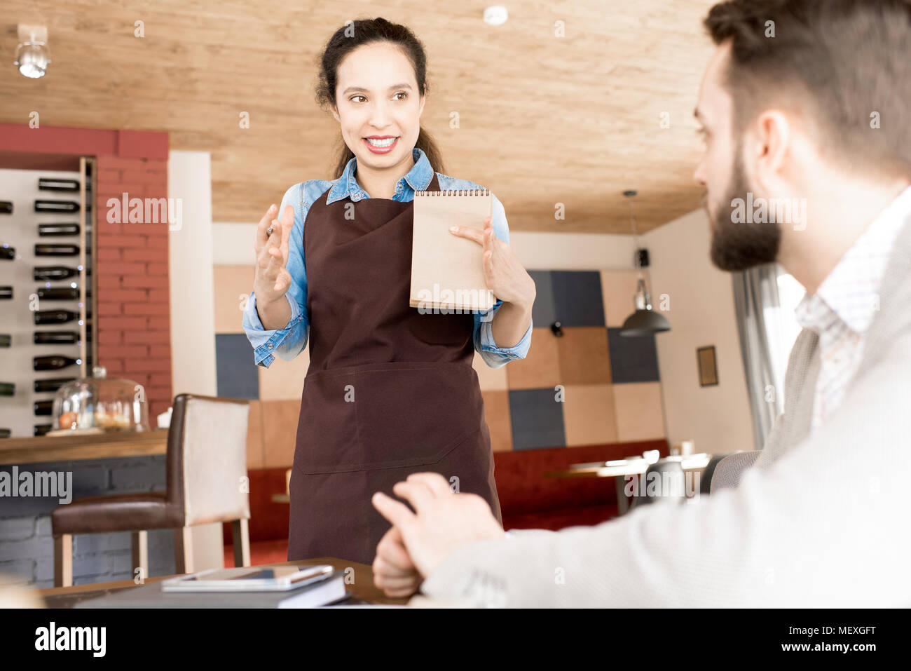 Travailler avec Hispanic waitress positive client Banque D'Images