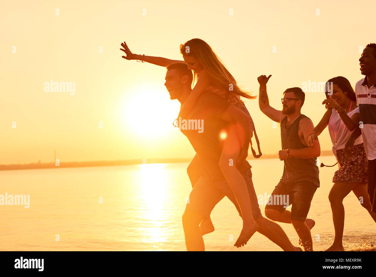 Amis hilarante tournant sur l'eau à la lumière du soleil Banque D'Images