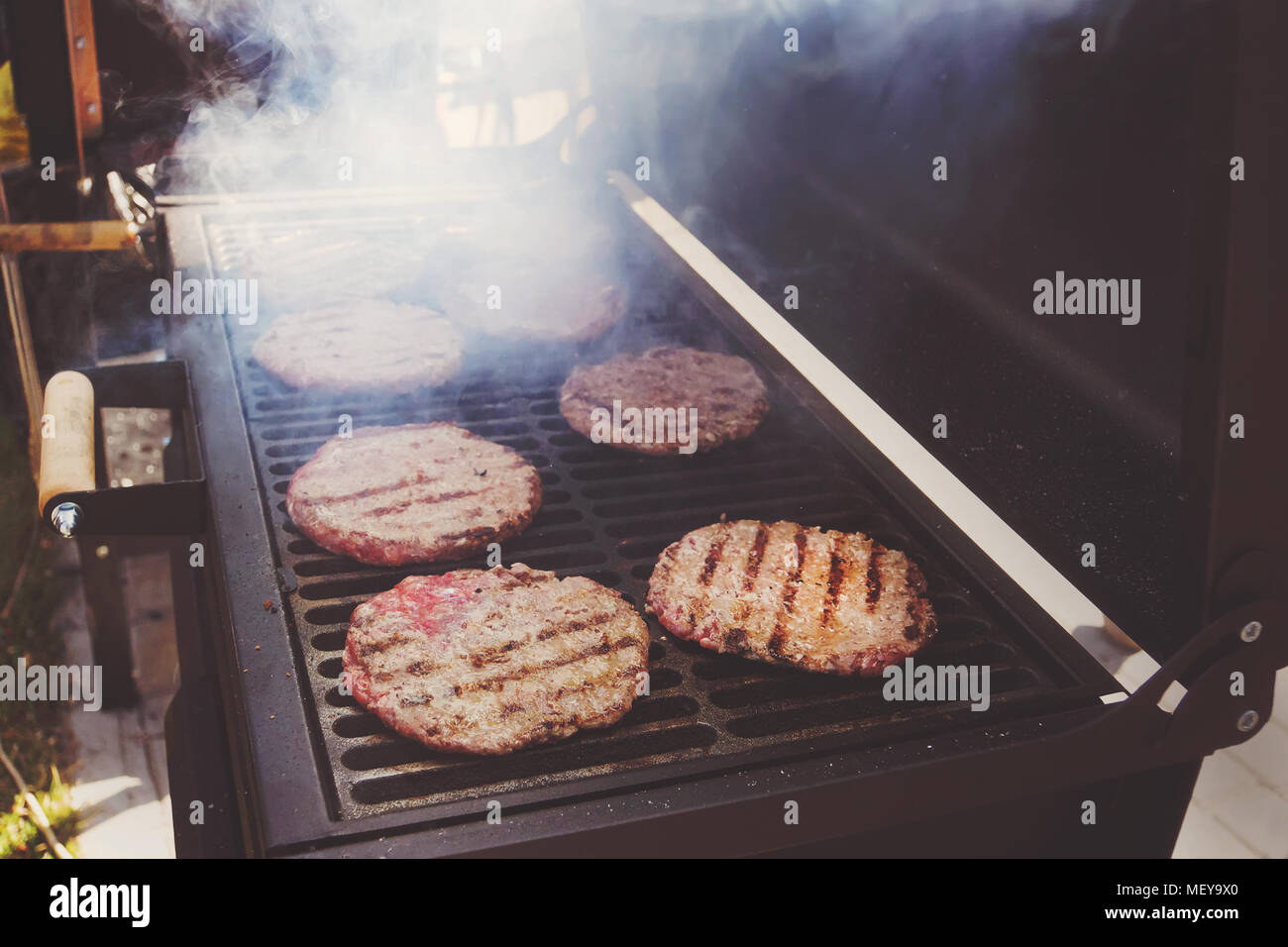Macro closeup vue des frais généraux des galettes de viande hachée de boeuf recette brûlée par grill et cuisson sur lignes marques barbecue à charbon noir Banque D'Images