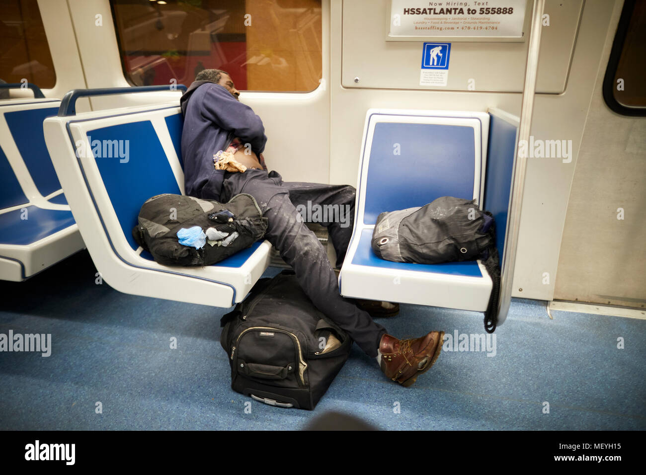 Atlanta capitale de l'état américain de Géorgie, un homme qui s'est endormie sur une chaise avec tous ses sacs autour de lui sur le système de métro MARTA Banque D'Images