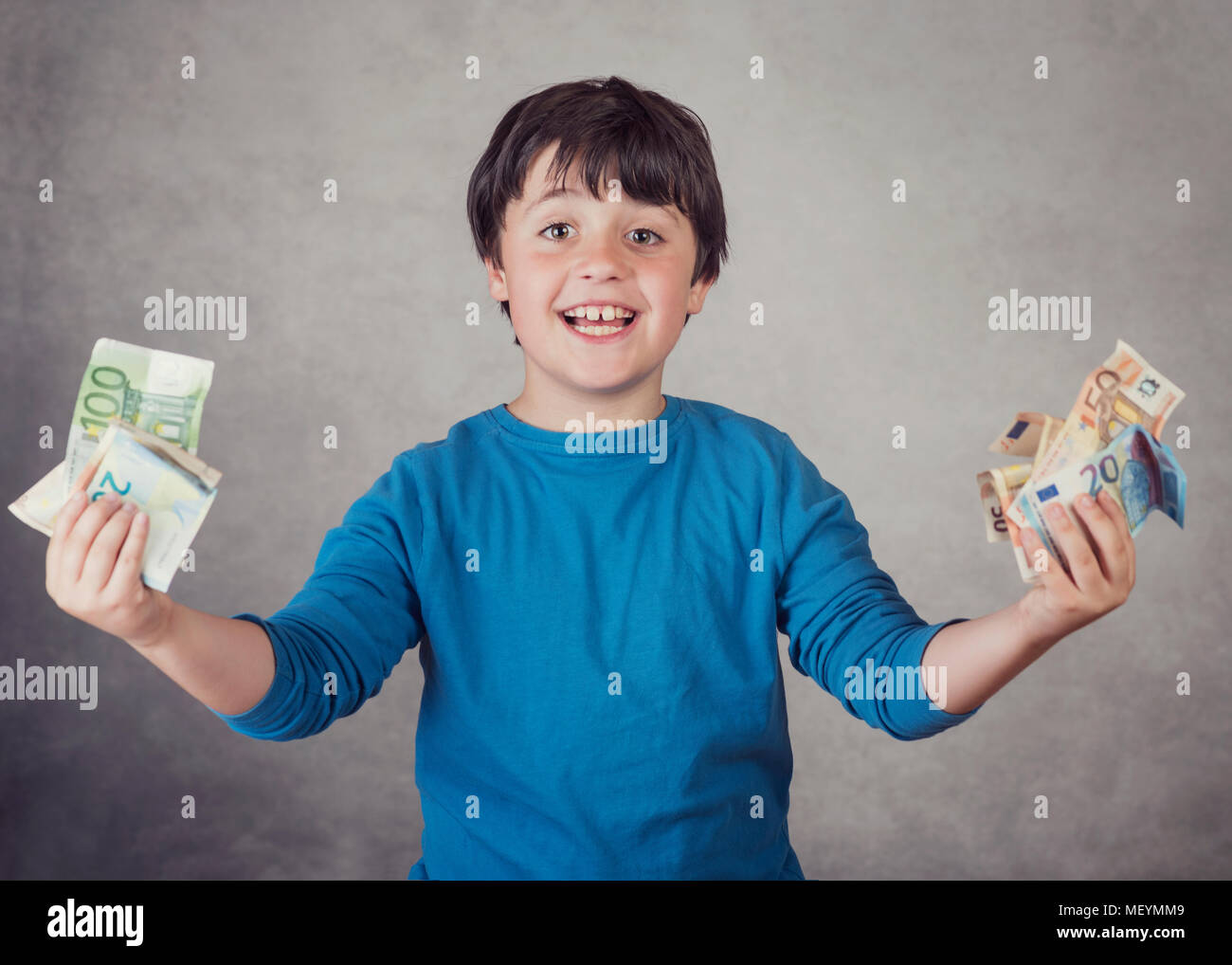 Smiling boy with euro bills sur fond gris Banque D'Images