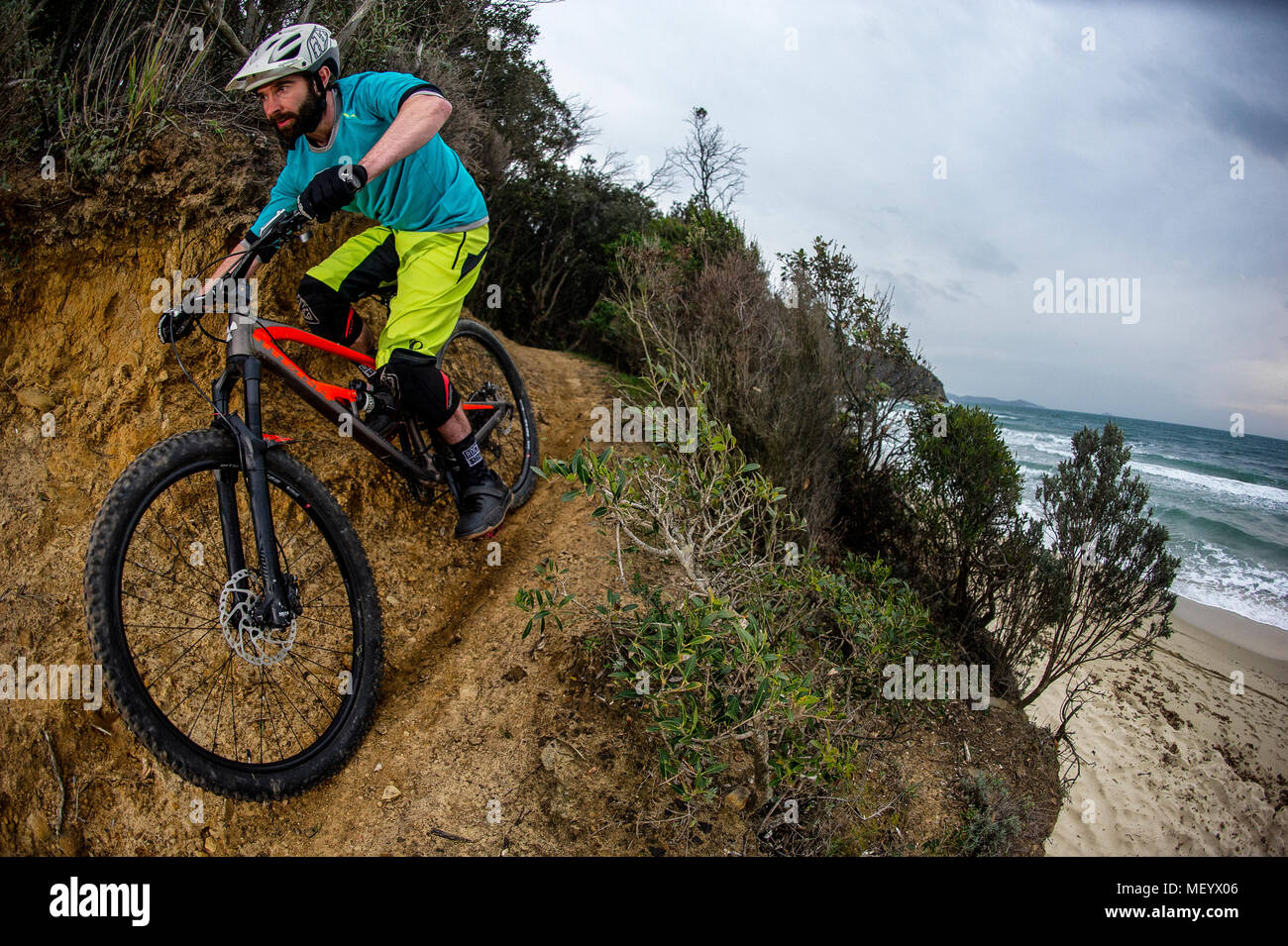 Un homme monte un vélo de montagne sur un sentier du littoral donnant sur la Mer Méditerranée près de Punta Ala en Toscane. L'Italie. Banque D'Images