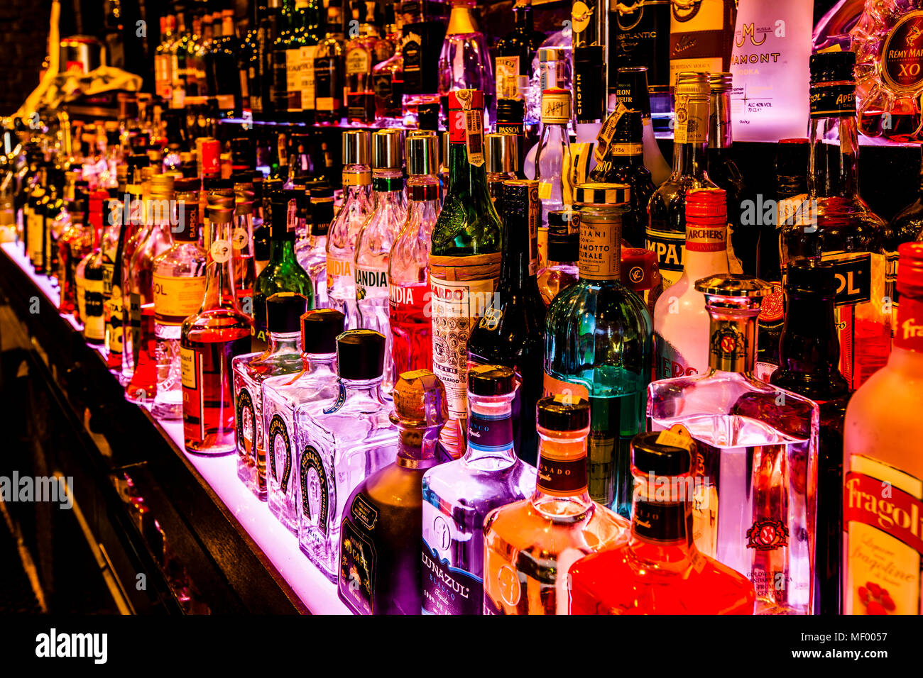 Des bouteilles d'alcool brillamment éclairées alignent les étagères du bar de l'Hotel Blow Up Hall 5050 à Poznań, en Pologne. Le bar propose un vaste menu de cocktails et est le seul bar en Pologne autorisé à permettre la fumée. Banque D'Images