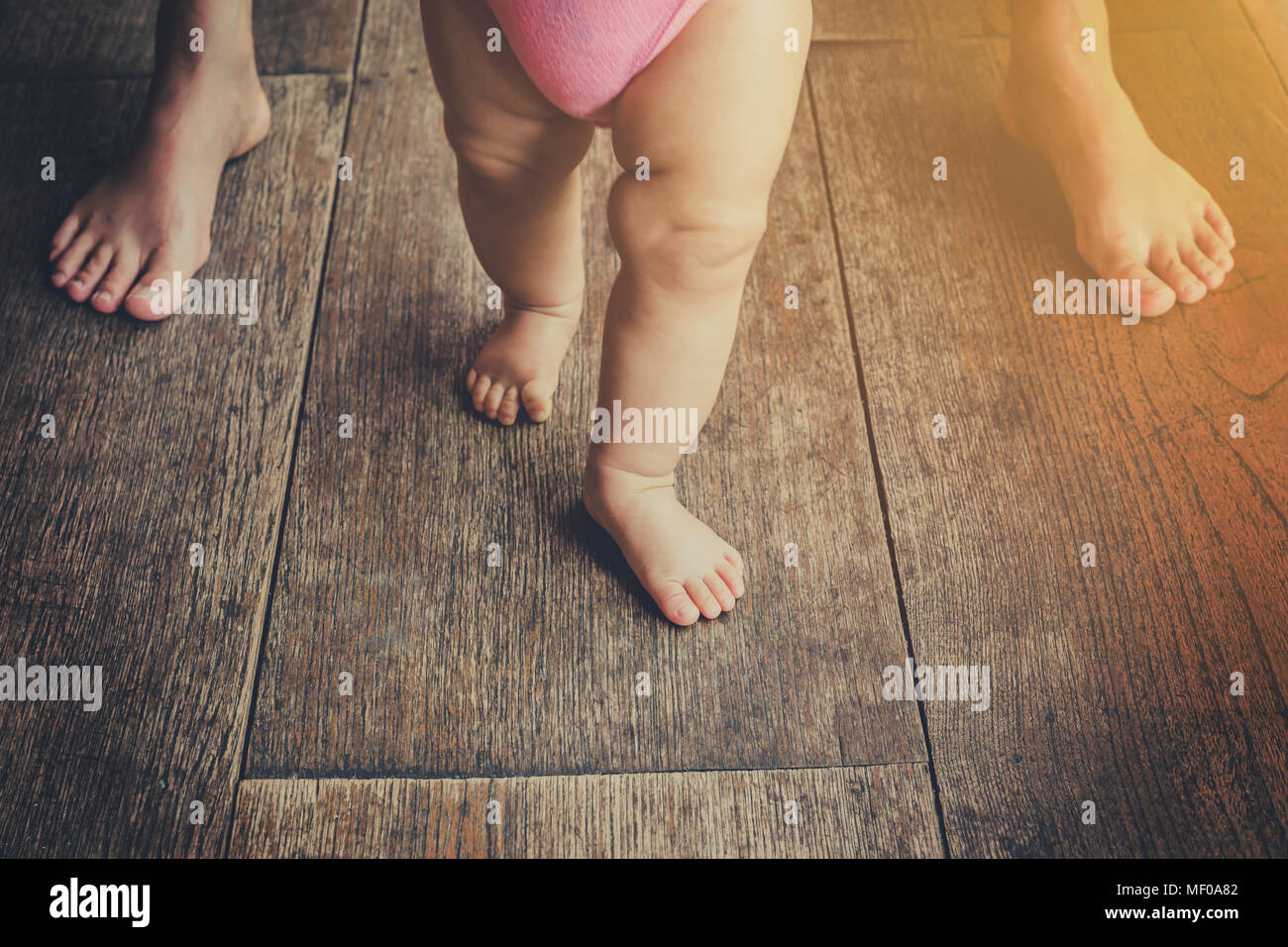 Bébé marche penchée avec mère, tons vintage. Banque D'Images