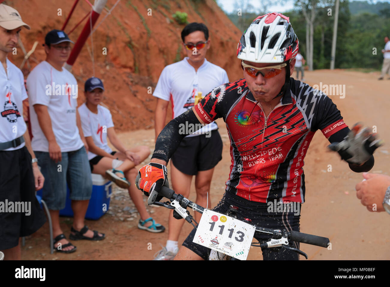 Biker remplissent leurs réservoir d'eau et prenez une banane à un point de contrôle de la PCC Présidentielle spécialisés Ride vtt 2013 compétition À Semenyih, Banque D'Images