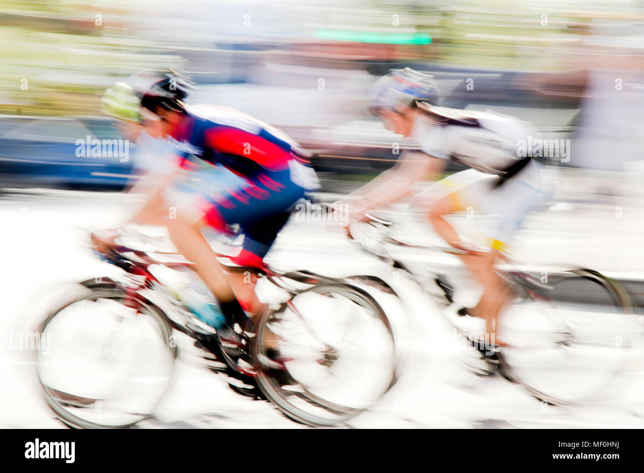 Résumé : L'arrière-plan flou artistique de deux jeunes coureurs de vélo en compétition sur les rues de la ville Banque D'Images