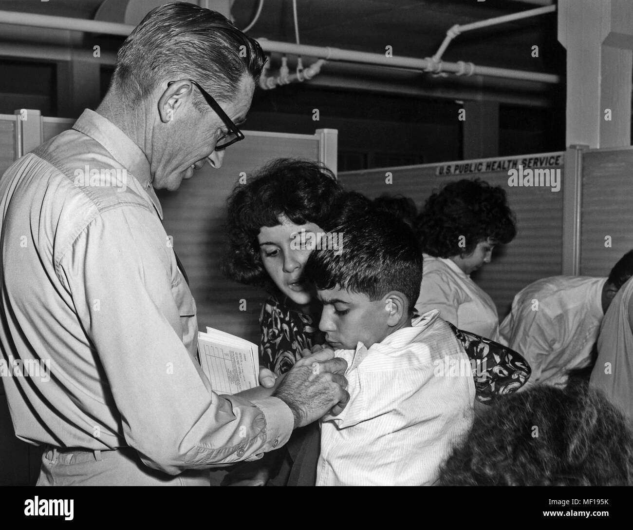 U.S. Public Health Service (PHS) représentant l'immunisation d'un garçon cubain cubain, l'émigration de masse, Miami, Floride, octobre 1965. Image courtoisie Centres for Disease Control (CDC). () Banque D'Images