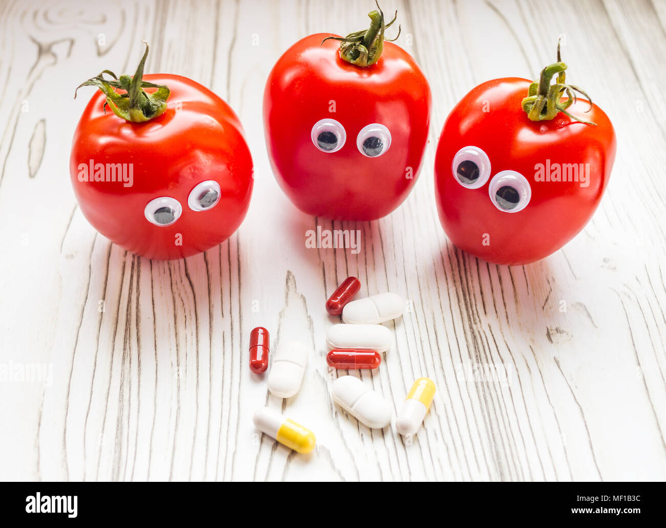 Les tomates avec les yeux regardant wobbly des suppléments de vitamine Banque D'Images