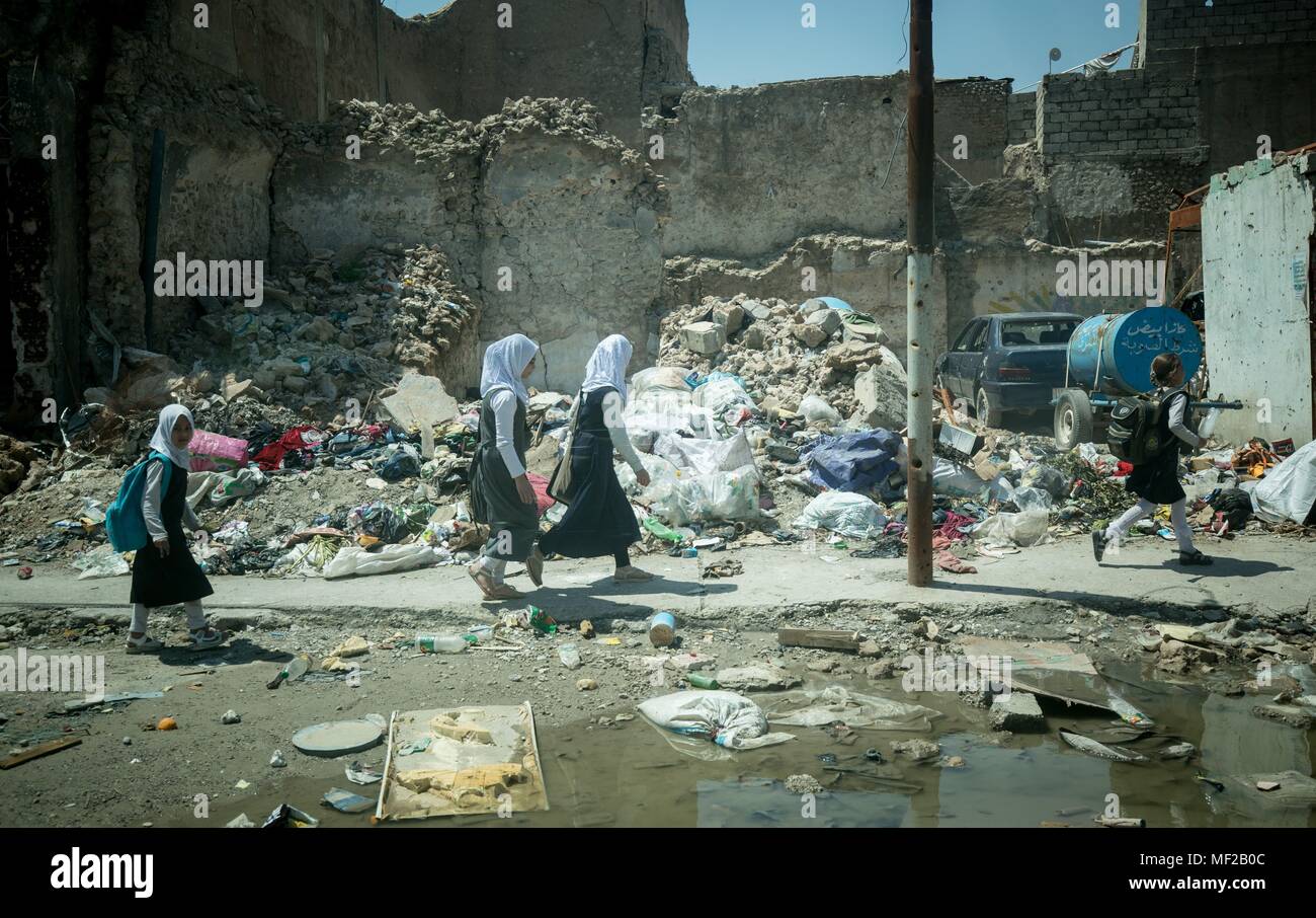 24 avril 2018, l'Irak, Mossoul : enfants de l'école marche à travers une ville détruite par l'État islamique. Le ministre du Développement allemand Gerd Mueller, de l'Union chrétienne sociale (CSU) est à l'Iraq de s'informer sur la reconstruction de ses villes détruites. Photo : Kay Nietfeld/dpa Banque D'Images