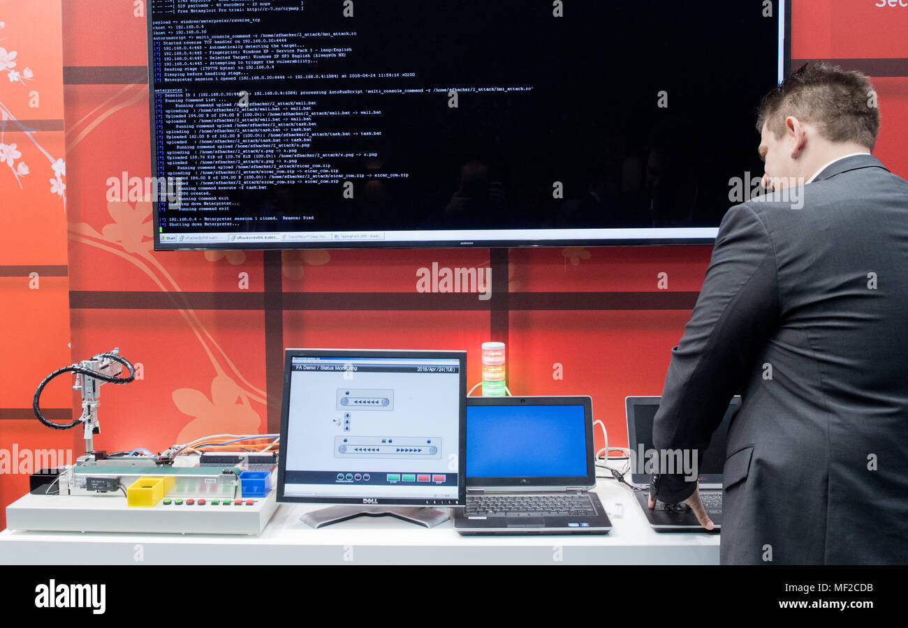 24 avril 2018, l'Allemagne, Hanovre : Un employé sur le stand de Trend Micro fait preuve d'une attaque de hacker pour les besoins de l'illustration à la Foire de Hanovre 2018. Trend Micro fournit des solutions matériel et logiciel de cyberattaques. Photo : Julian Stratenschulte/dpa Banque D'Images