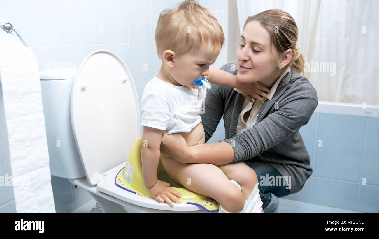 Jeune femme des sons de son bébé garçon sur les toilettes Banque D'Images