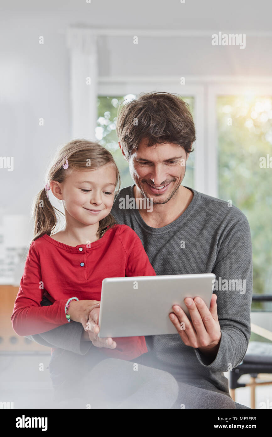 Smiling père et fille à l'aide de tablet ensemble, à la maison Banque D'Images
