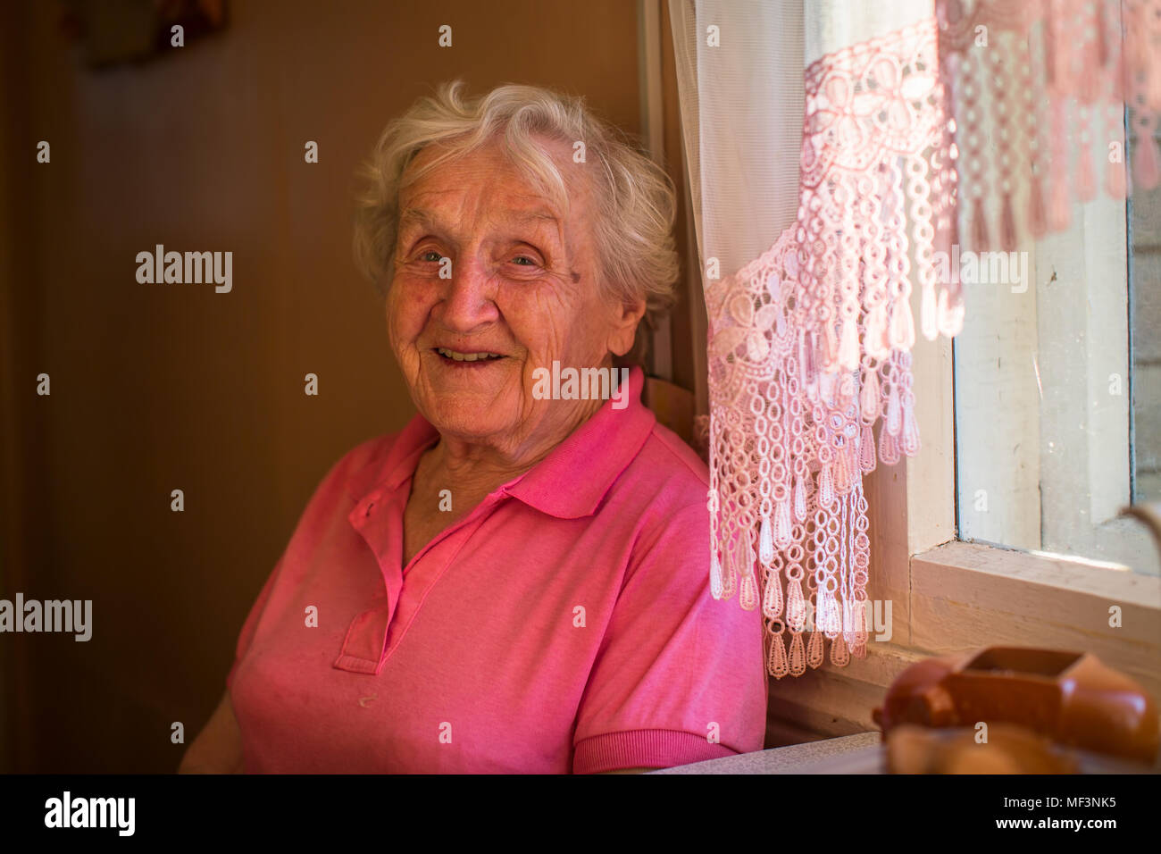 Portrait d'une femme âgée assise à la table. Banque D'Images