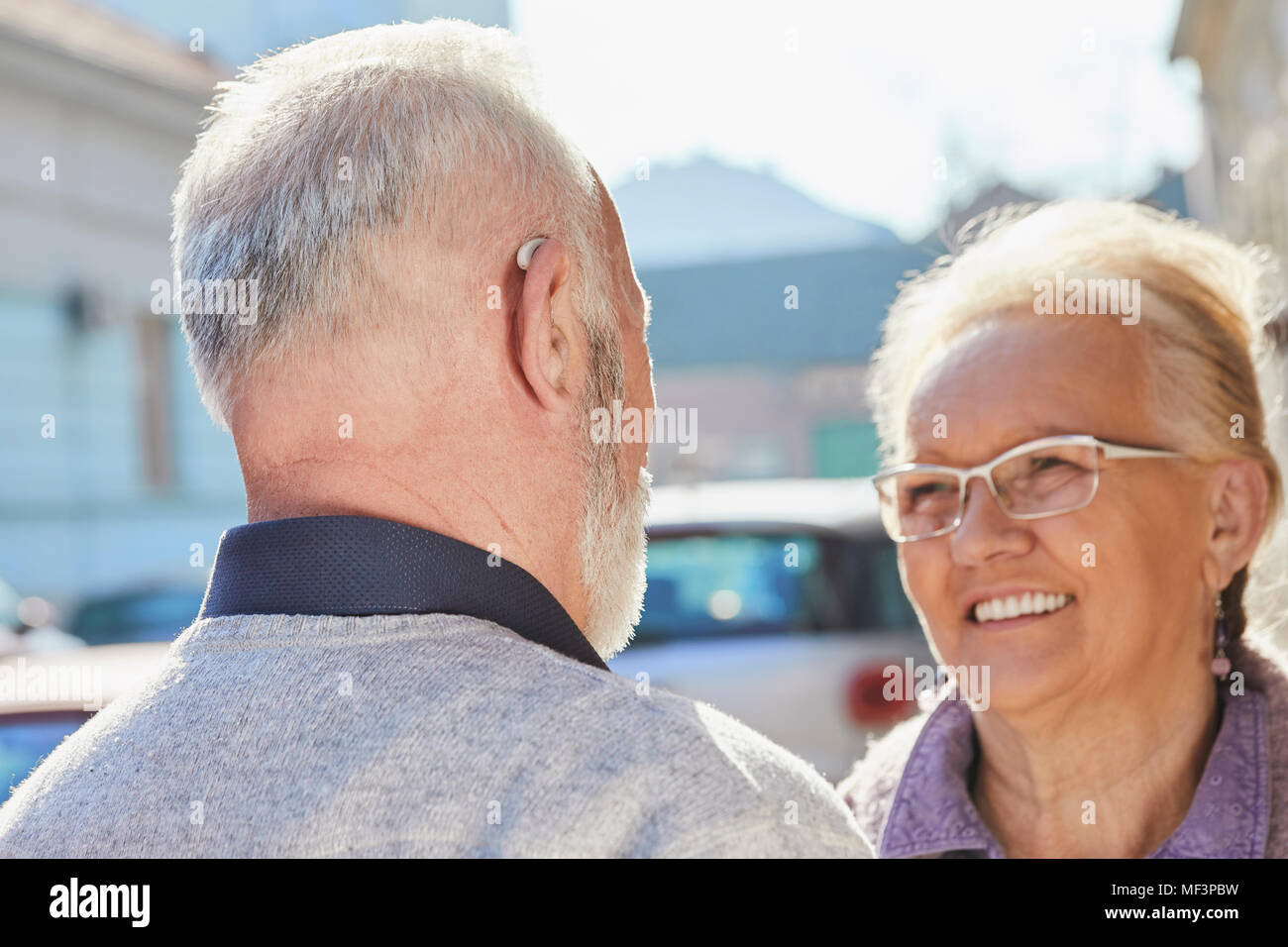 Close-up of senior man with hearing aid parler à senior woman Banque D'Images