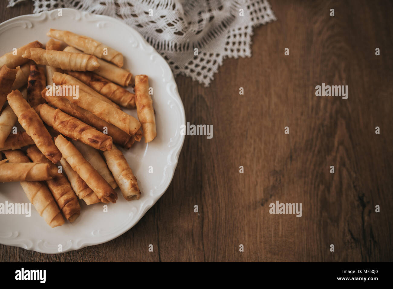 Cigarette turque galette sur plaque blanche et table en bois. Banque D'Images Cigarette turque galette sur plaque blanche et table en bois. Banque D'Images