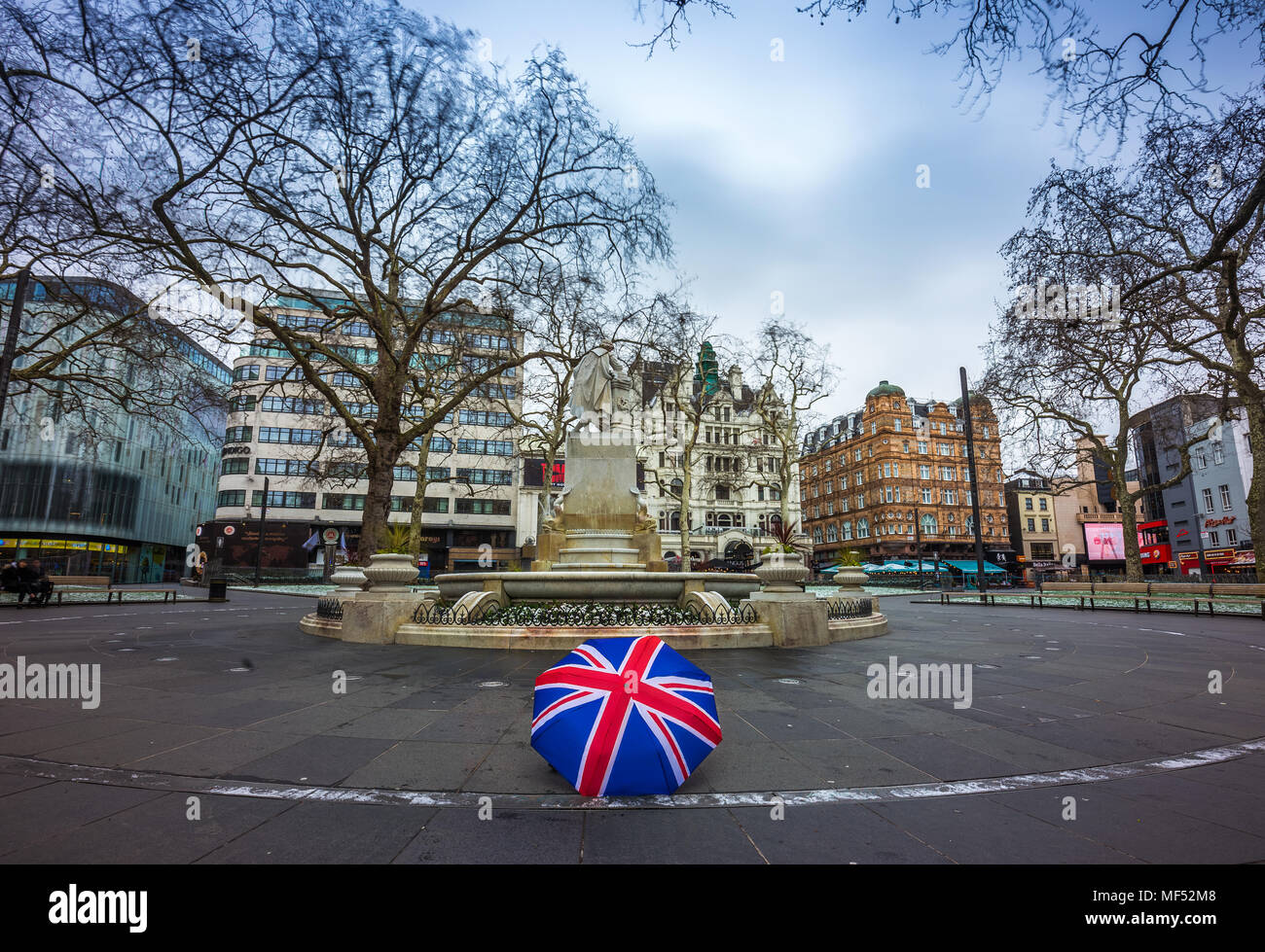 Londres, Angleterre - 03.18.2018 : Union Jack iconique parasol à Leicester Square avec la statue de William Shakespeare sur un matin nuageux Banque D'Images