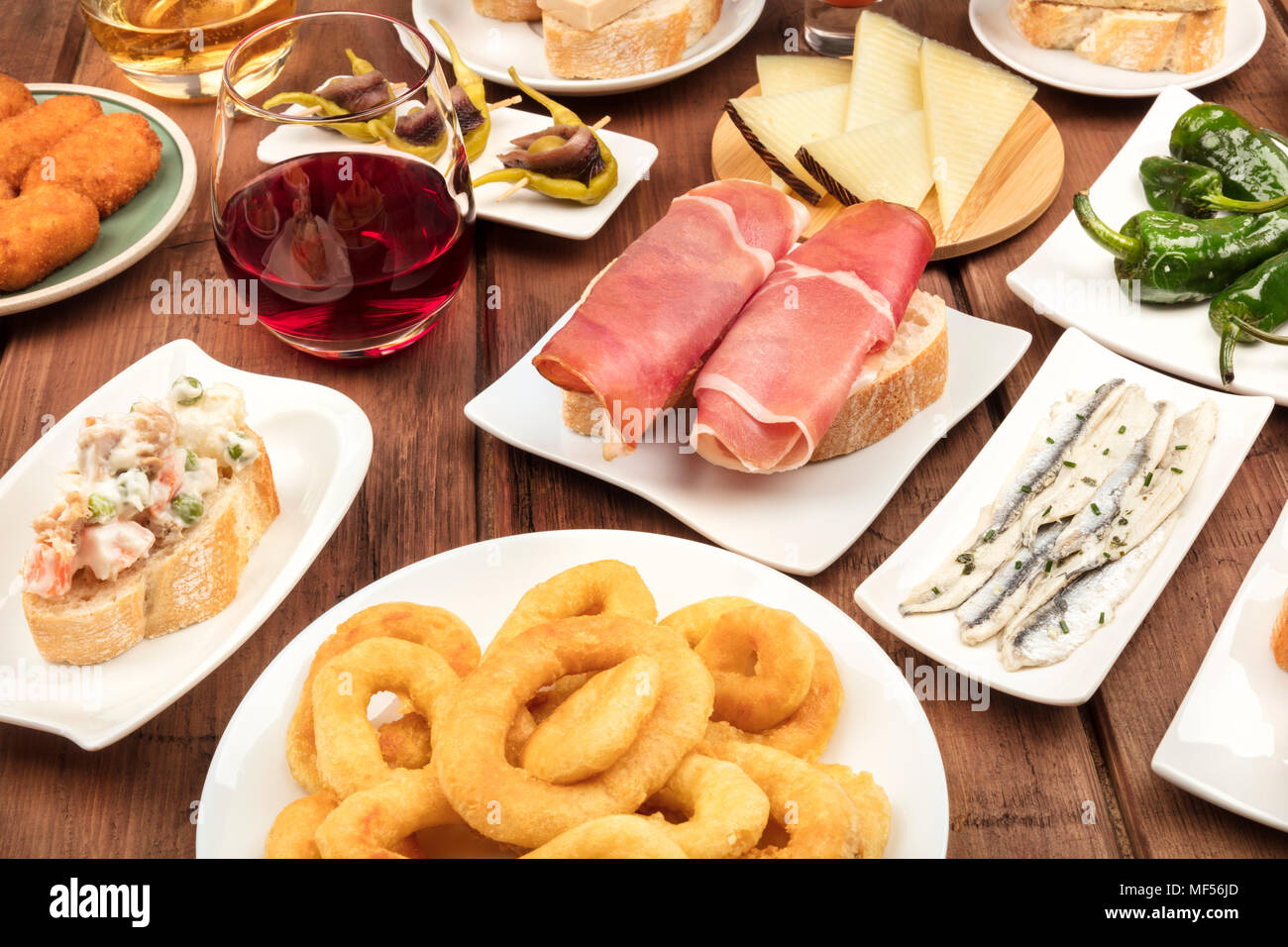 La nourriture de l'Espagne. Une photo de beaucoup de différents tapas espagnoles sur une texture rustique. Jambon, fromage, vin, croquettes, Anneaux de calamars, anchois et mo Banque D'Images