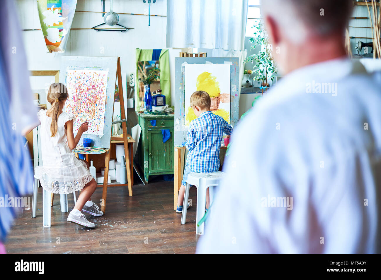L'observation de l'enseignant en peinture pour enfants Art Studio Banque D'Images