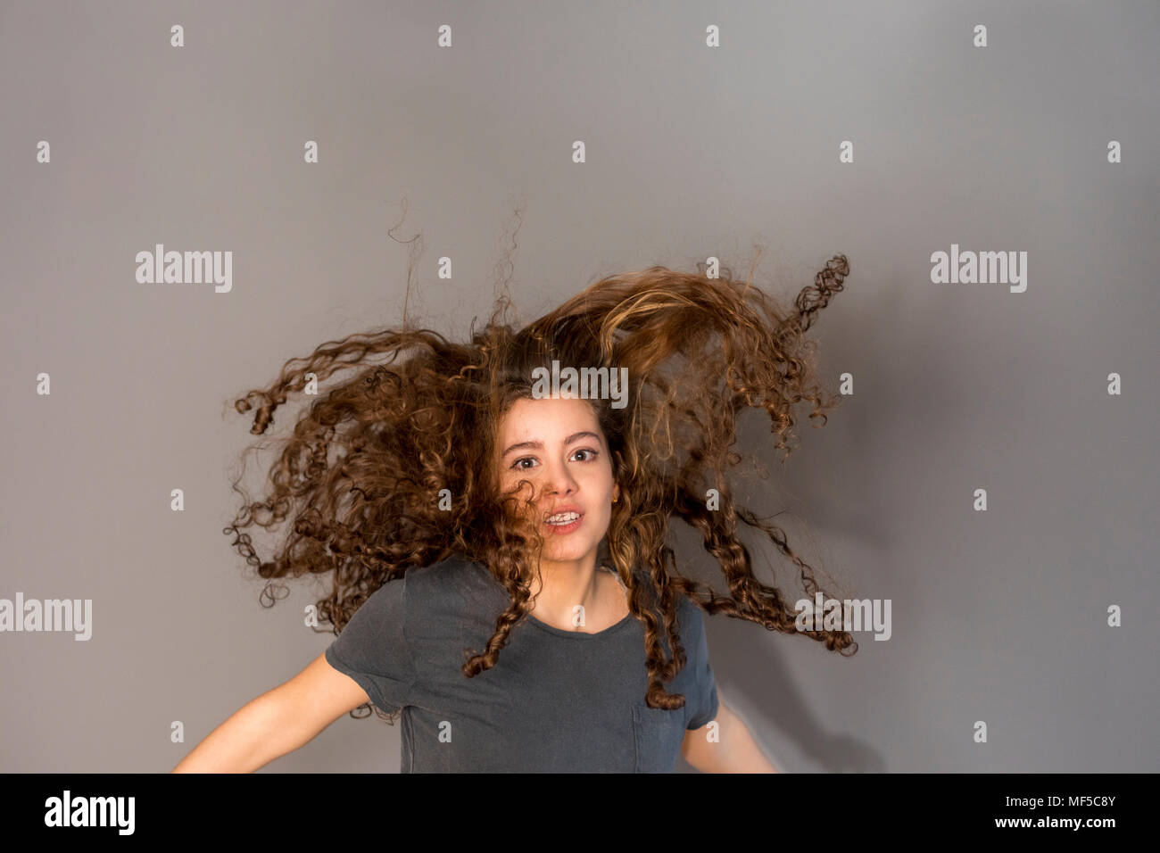 Pretty woman avec des cheveux bouclés, sautant Banque D'Images