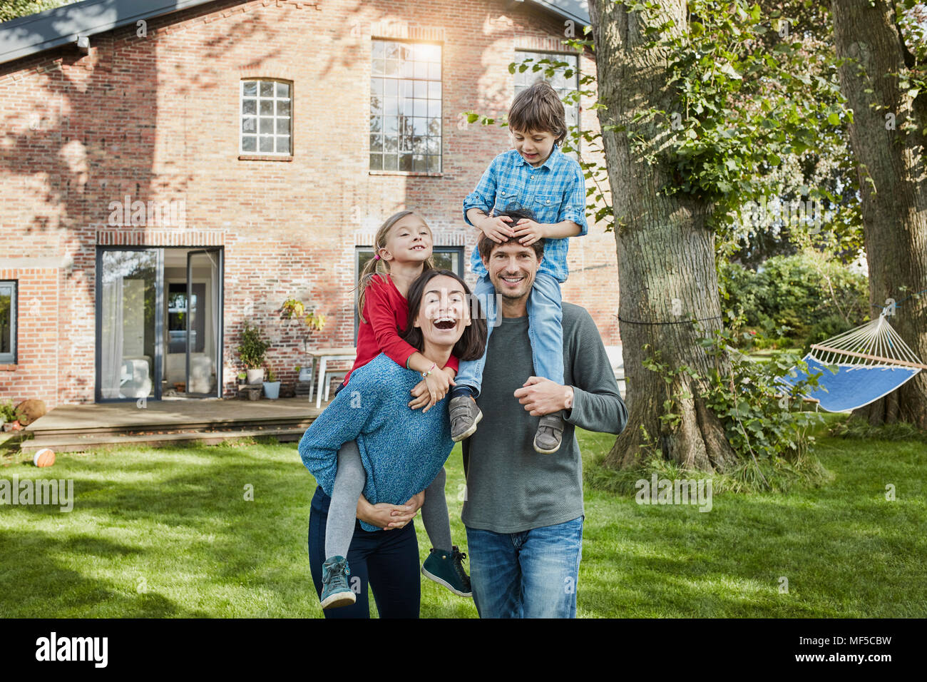 Portrait de famille heureuse dans le jardin de leur maison Banque D'Images