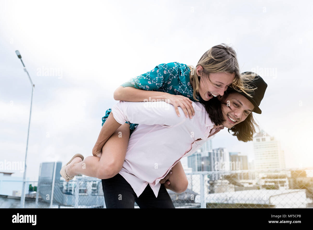 Young affectionate couple s'amuser ensemble sur le toit Banque D'Images