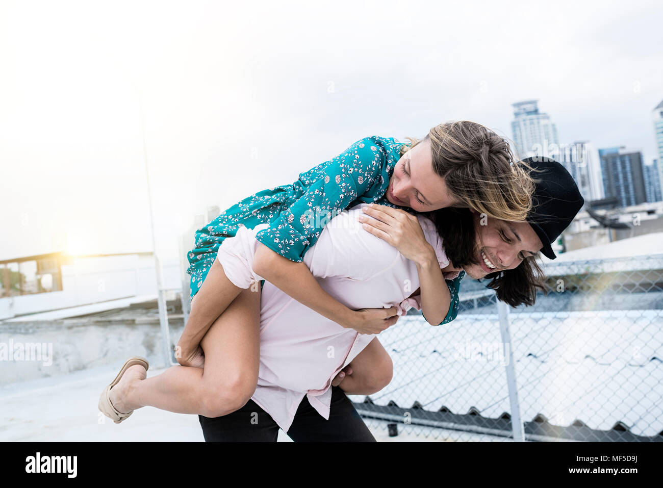 Young affectionate couple s'amuser ensemble sur le toit Banque D'Images