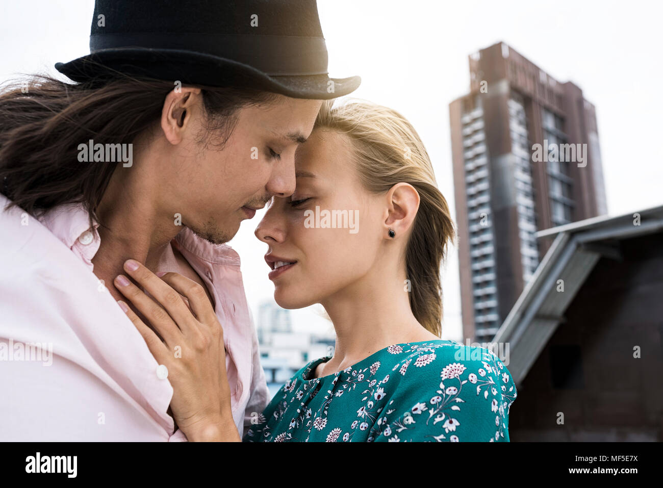 Young affectionate couple kissing on rooftop Banque D'Images