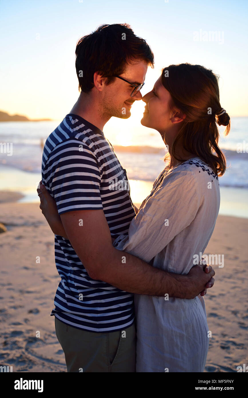 Couple romantique sur la plage au coucher du soleil Banque D'Images