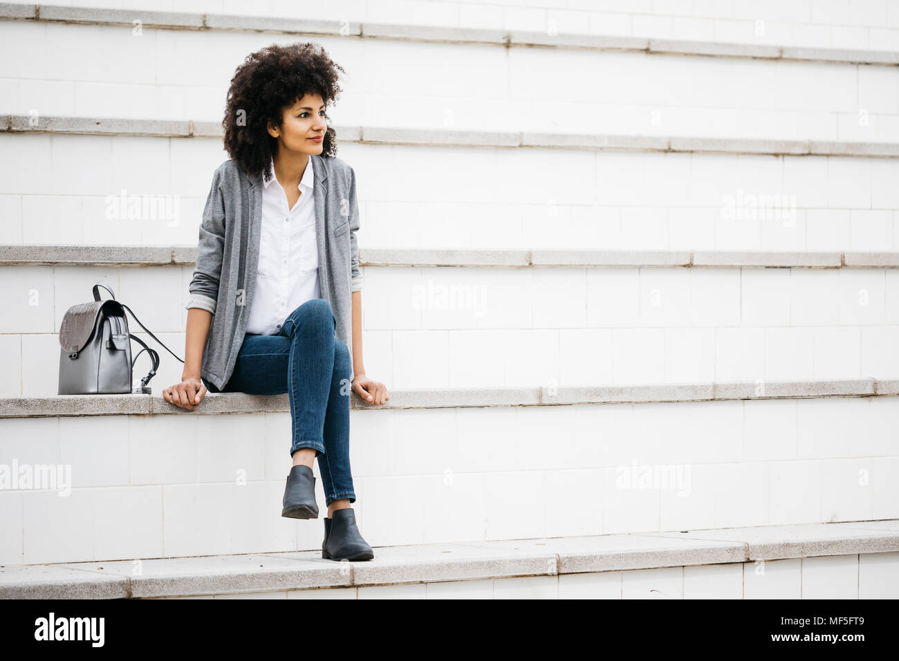 Femme reposant sur l'escalier extérieur Banque D'Images