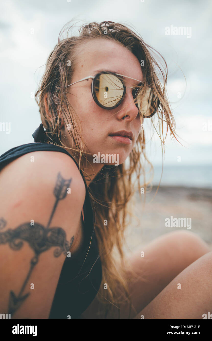 Portrait d'une jeune femme avec des lunettes et un tatouage Banque D'Images