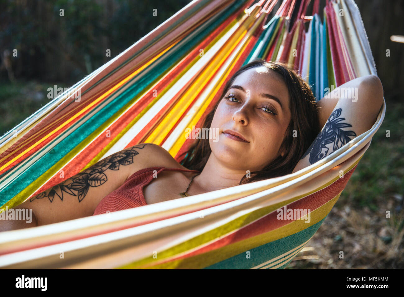 Portrait of young woman with tattoo couché dans un hamac Banque D'Images