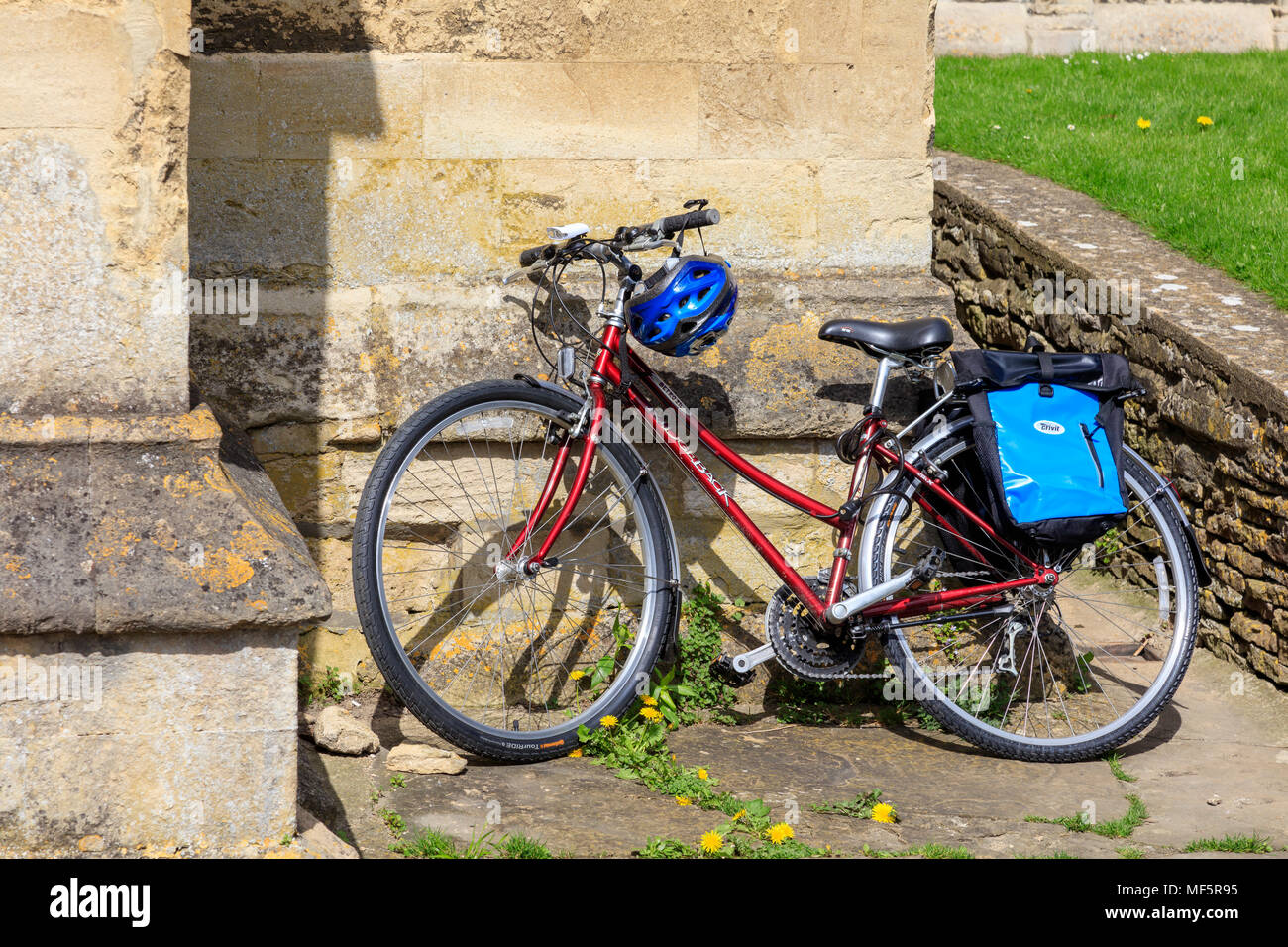 Un cycliste quitte un vélo appuyé contre le mur de l'abbaye de Malmesbury pendant qu'ils visitent, Wiltshire, Royaume-Uni Banque D'Images