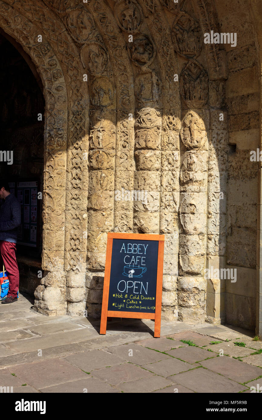 Un panneau indiquant l'abbaye Café est ouvert à l'entrée voûtée décorée à l'abbaye de Malmesbury, Wiltshire, Royaume-Uni Banque D'Images