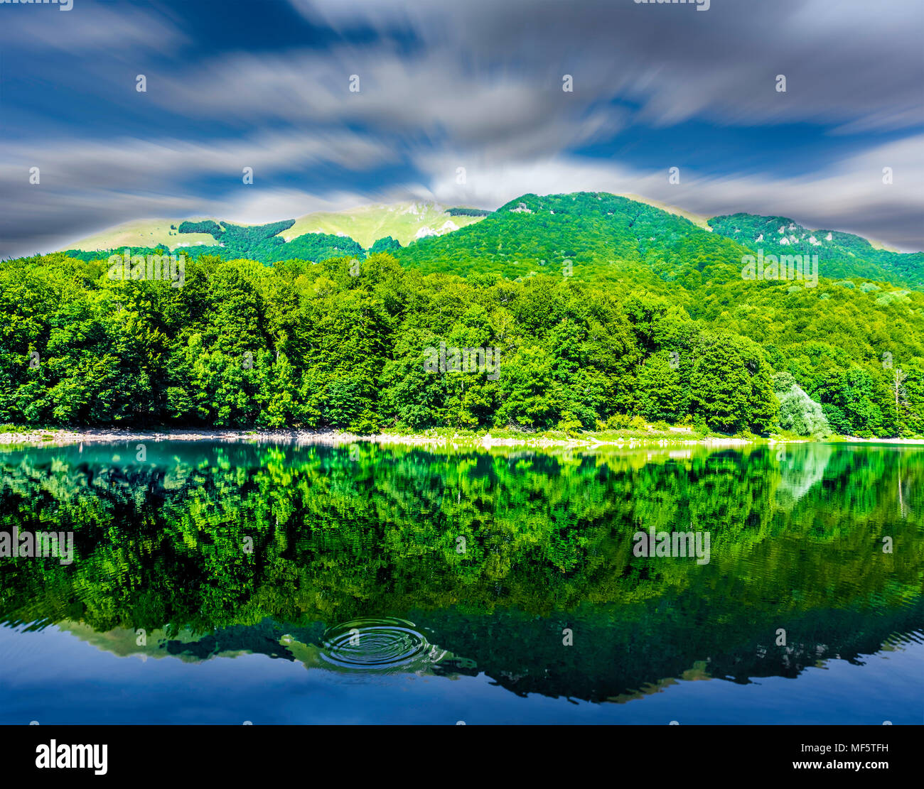 Magnifique paysage de lac de montagne aux beaux jours d'été avec speedy nuages sur ciel bleu, vert forêt et la mise en miroir d'eau calme forêt, Ciel et nuages. Banque D'Images