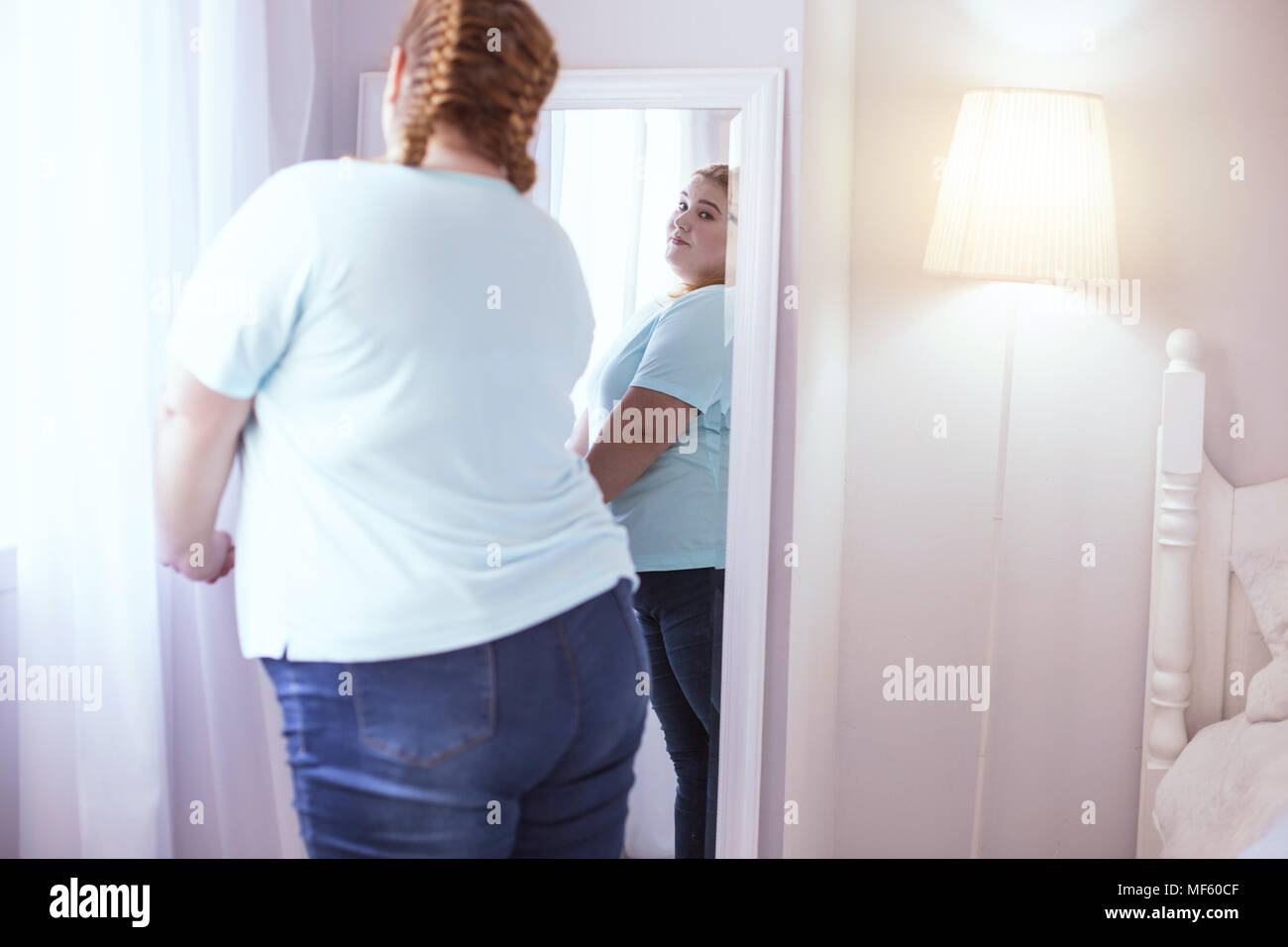 Femme obèse à la recherche dans le miroir Banque D'Images