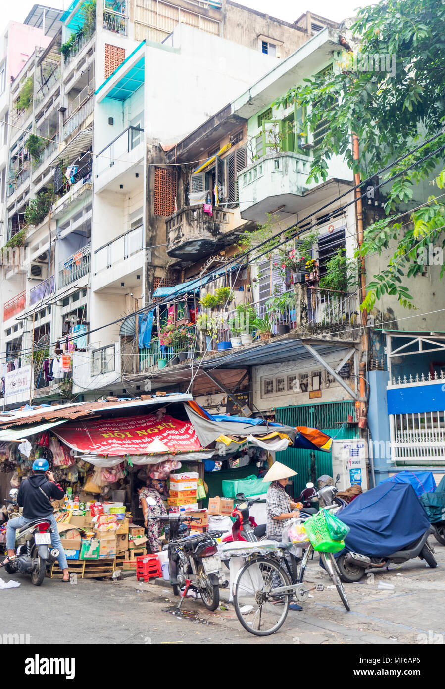 Une Vietnamienne portant un chapeau conique chargement des sacs de shopping sur son vélo dans la tonne ce barrage des marchés de rue, Ho Chi Minh City, Vietnam. Banque D'Images