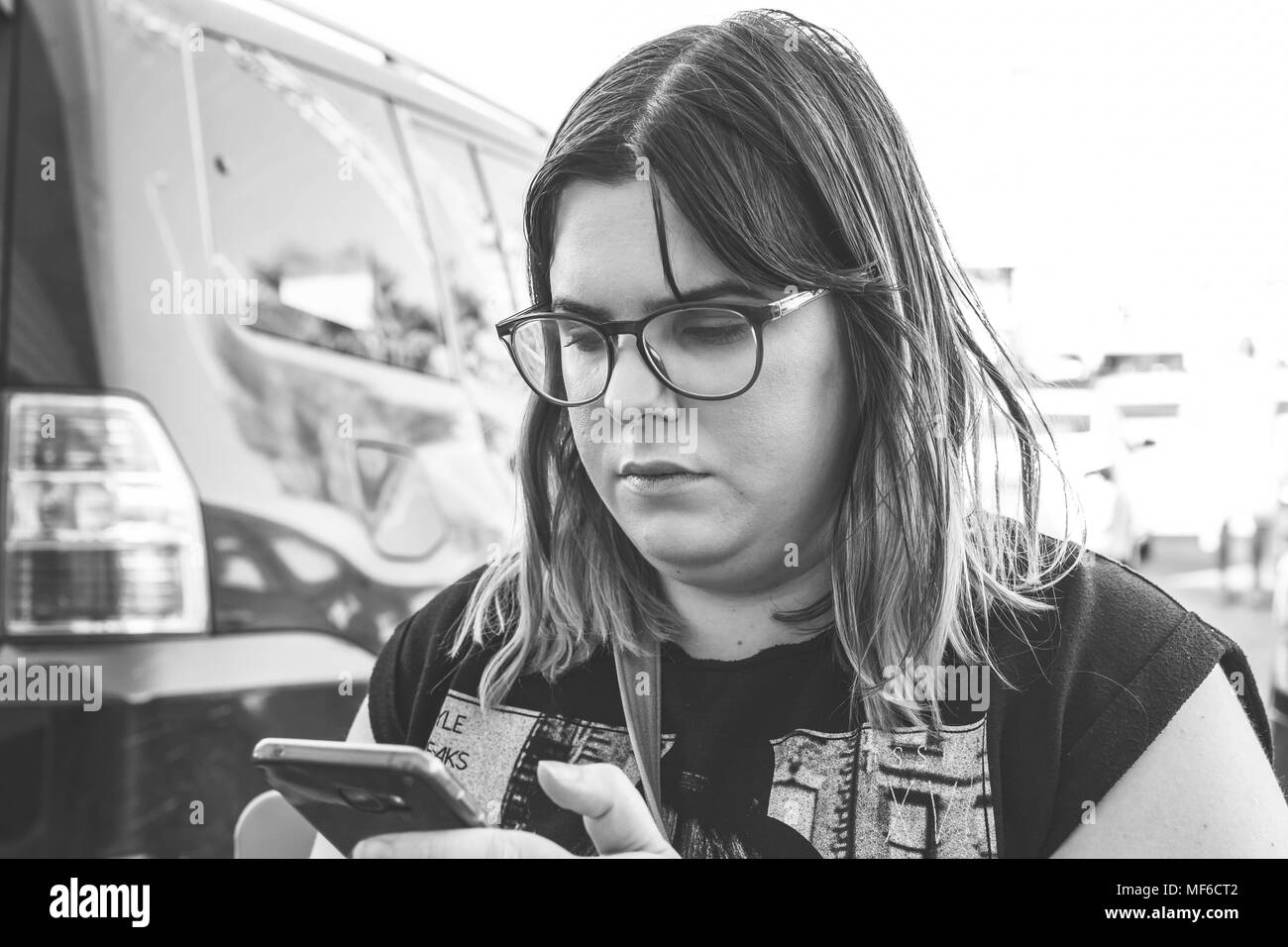 Femme à l'aide du smartphone sur la rue. Close up noir blanc image. Banque D'Images