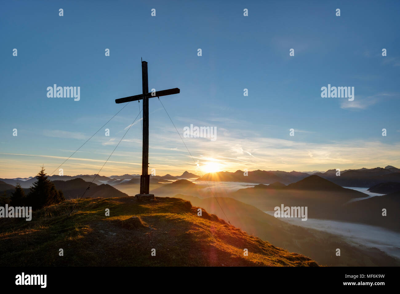Le lever du soleil, le sommet cross à Hirschhörnlkopf, Jachenau, Isarwinkel, Haute-Bavière, Bavière, Allemagne Banque D'Images