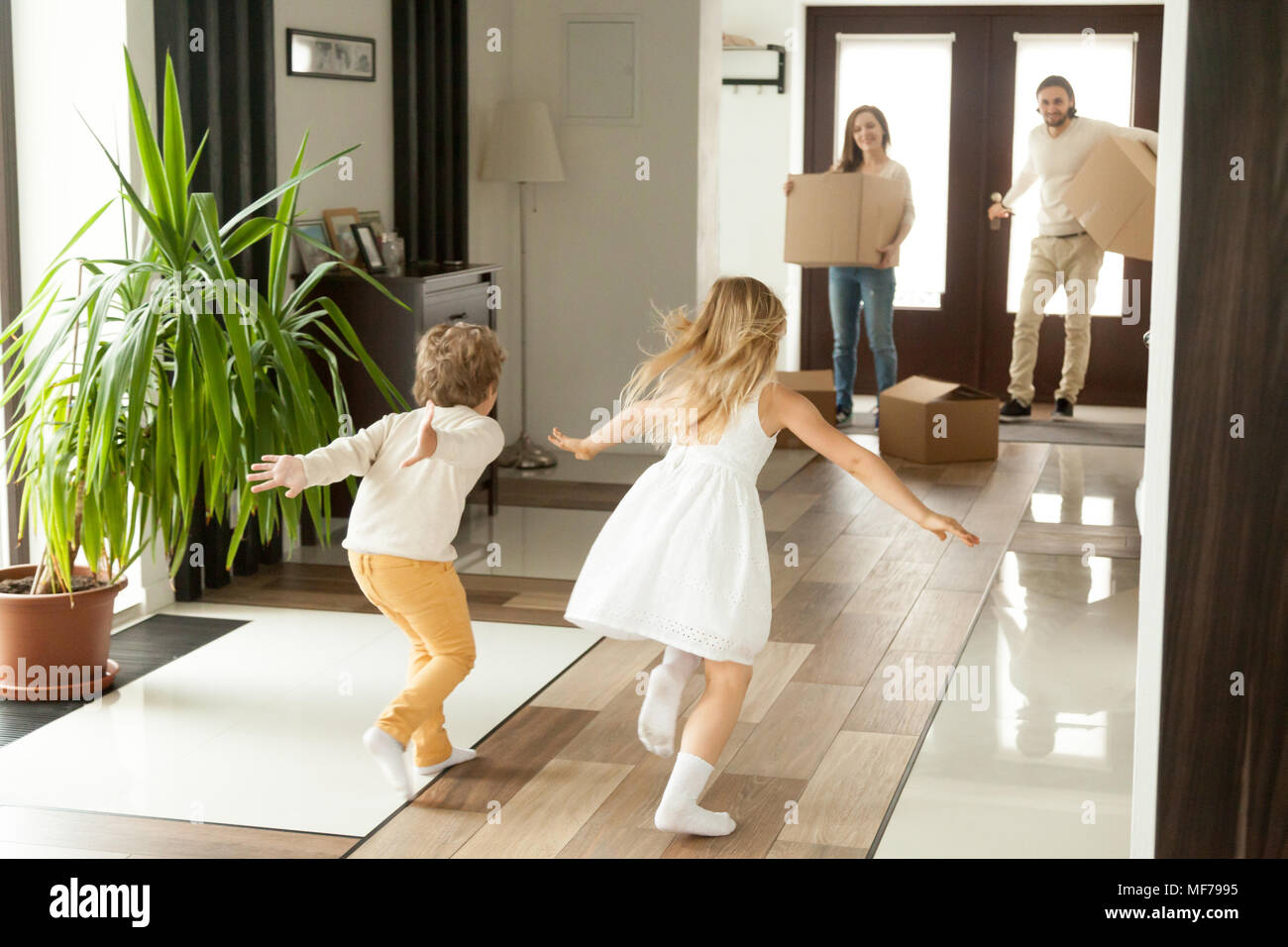 Vue arrière en tournant les enfants aux parents le jour du déménagement Banque D'Images