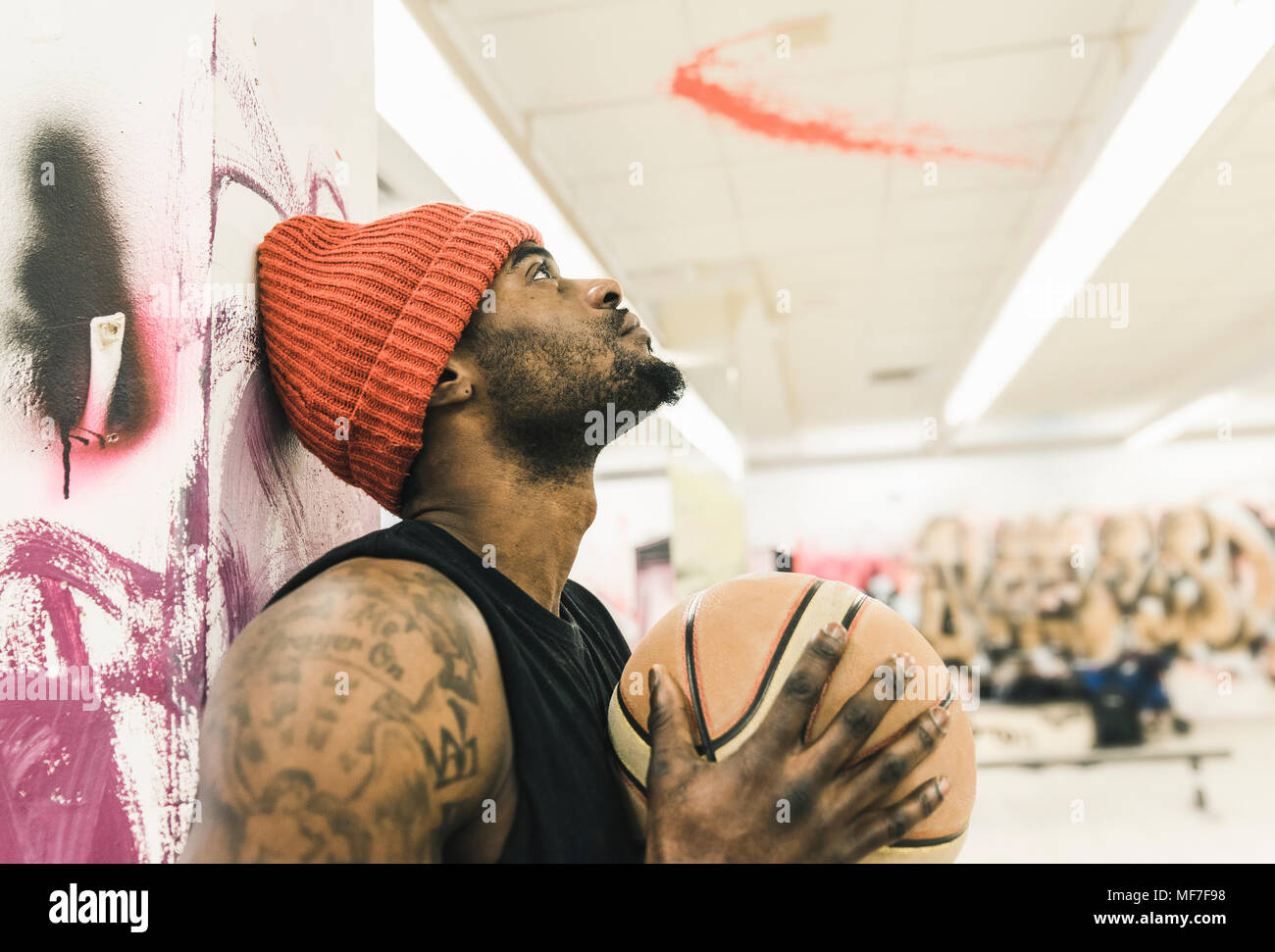 Homme avec tatouages et woolly hat holding basketball Photo Stock - Alamy