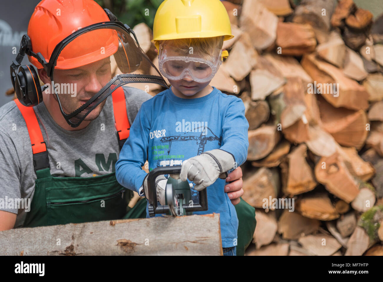 Père et fils scier du bois ensemble Banque D'Images