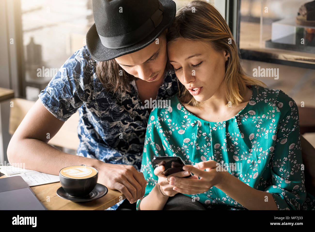 Artiste couple sitting in cafe et le contrôle de la jeune femme. Banque D'Images
