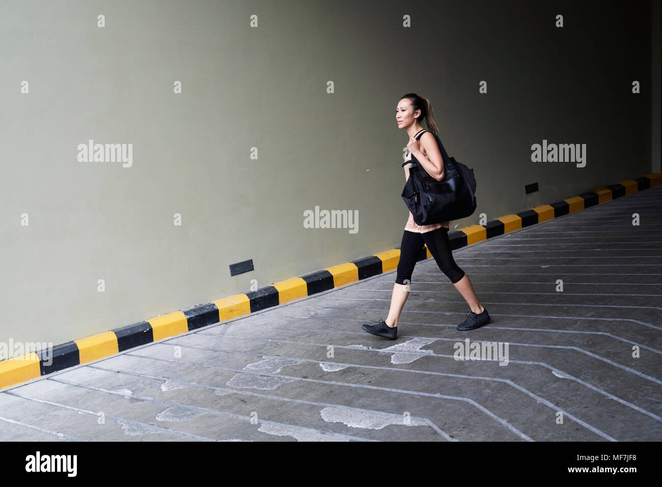 Confiant fit woman walking au garage Banque D'Images